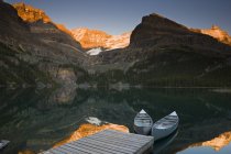 Canoe ormeggiate dal molo sul lago OHara al tramonto, Columbia Britannica, Canada — Foto stock