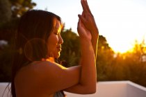 Close-up de mulher praticando ioga ao amanhecer luz solar em Kalymnos, Grécia — Fotografia de Stock