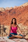 Donna in forma che pratica yoga su rocce rosse del deserto del Mojave, Las Vegas, Nevada, Stati Uniti d'America — Foto stock