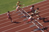 Track and field competition, hurdlers on rust coloured track, British Columbia, Canada. — Stock Photo