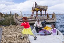 Residenti locali con bambino di canne galleggianti isole di Uros, Lago Titicaca, Perù — Foto stock