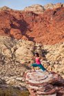 Fit woman practicing yoga on red rocks of Mojave Desert, Las Vegas, Nevada, Estados Unidos da América — Fotografia de Stock