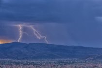 Fulmine durante il temporale al tramonto sul paesaggio urbano di Cochabamba in Bolivia . — Foto stock