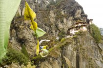 Prayer flags and low angle view of Tiger Nest monastery in Bhutan. — Stock Photo