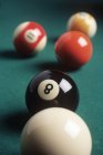 Eight ball and billiard balls on green table, close-up — Stock Photo