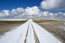 Estrada de cascalho coberta de neve perto de Hazenmore, Saskatchewan, Canadá — Fotografia de Stock