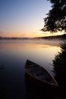 Canoa ao amanhecer na costa do Lago Sawyer, Parque Algonquin, Ontário, Canadá — Fotografia de Stock