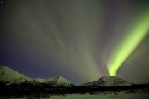 Aurora borealis above mountains outside of Whitehorse, Yukon, Canada. — Stock Photo