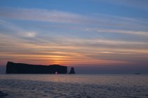 Sol nascendo atrás de Perce Rock em Gaspesie, Quebec, Canadá . — Fotografia de Stock