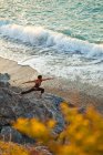 Vista ad alto angolo della donna che fa yoga al tramonto vicino alla spiaggia di Kalymnos, Grecia — Foto stock