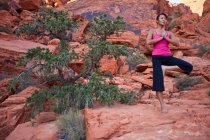 Fit woman practicing yoga on red rocks of Mojave Desert, Las Vegas, Nevada, Estados Unidos da América — Fotografia de Stock