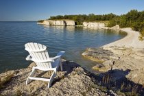 Chair by limestone cliffs along Lake Manitoba, Manitoba, Canada — Stock Photo