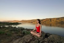 Junge Frau entspannt sich mit Yoga über den Kamloops-See an einem schönen Abend, Kamloops, Britisch Columbia, Kanada — Stockfoto