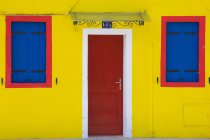 Яскраво-жовта стіна з дверима і вікнами — стокове фото