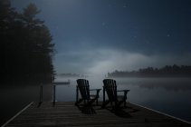Sillas Adirondack en el lago Kahshe, Muskoka, Ontario - foto de stock
