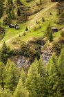 Small wooden huts on green slopes of Dolomite Mountains in northern Italy. — Stock Photo