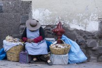 Местная женщина с корзинами спит на улице деревни Писак, Перу — стоковое фото