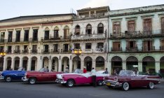 Amerikanische Oldtimer, die von der Fassade eines alten Gebäudes in Havanna, Kuba, ausgestellt werden — Stockfoto