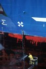 Werftarbeiter Powerwashing Rumpf von Stahlschiff, Victoria, Vancouver Island, British Columbia, Kanada. — Stockfoto