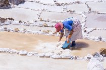 Mujer local que trabaja en las minas de sal de Maras en la región de Cuzco, Perú - foto de stock