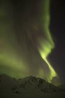 Luzes verdes do norte no céu noturno escuro sob Dempster Highway, Yukon, Canadá . — Fotografia de Stock