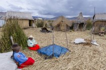 Residentes locales de la isla de caña flotante de Uros, Lago Titicaca, Perú - foto de stock