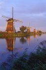 Vecchi mulini a vento lungo il canale d'acqua all'alba a Kinderdijk, Paesi Bassi — Foto stock