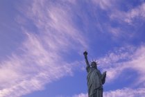 Vista de baixo ângulo da Estátua da Liberdade contra o céu azul nublado em Nova York, EUA — Fotografia de Stock