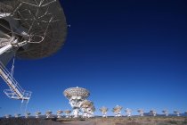 Large gamme de antennes paraboliques contre le ciel bleu au Nouveau-Mexique, États-Unis . — Photo de stock