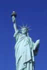 Vista ad angolo basso della Statua della Libertà contro il cielo blu a New York, USA — Foto stock