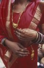 Midsection of woman with henna hands tattoos, red sari and gold jewelry, Jaipur, Rajsatan, India — Stock Photo