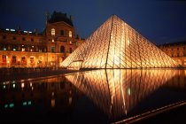 Pirámide del Louvre iluminada por la noche en París, Francia - foto de stock