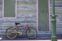 Vélo de croisière avec peinture personnalisée appuyée sur le mur de vieux bâtiment, Key West, Floride, États-Unis — Photo de stock