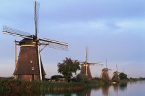 Old windmills by water canal at dusk in Kinderdijk, Netherlands — Stock Photo