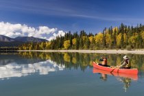 Hombre y mujer navegando en canoa en Bowron Lake Provincial Park, Columbia Británica, Canadá . - foto de stock