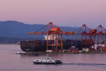 Port of Vancouver, cranes and freighter at dusk, British Columbia, Canada. — Stock Photo