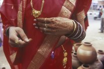 Mittelteil der Frau mit Henna-Hände-Tätowierungen, rotem Sari und Goldschmuck, Jaipur, Rajsatan, Indien — Stockfoto