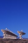 Gran variedad de antenas parabólicas contra el cielo azul en Nuevo México, EE.UU. . - foto de stock
