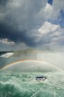 Туристическая лодка под радугой у водопада Подкова, Ниагарский водопад, Онтарио, Канада . — стоковое фото