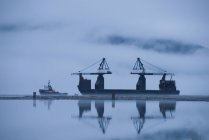 Краны поднимают и складывают бревна на поверхности палубы в Портлендском канале, порт Стюарт, Канада — стоковое фото