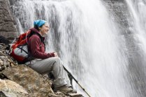 Mulher adulta média descansando em Seven Veils Falls perto do Lago Ohara no Parque Nacional Yoho, Colúmbia Britânica, Canadá . — Fotografia de Stock