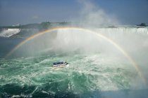 Horseshoe Falls and American Falls and rainbow over tour boat at Niagara Falls, Ontario, Canada — Stock Photo