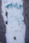 Männlicher Eiskletterer, der am Geisterfluss den Berg hinaufsteigt, Alberta, Kanada — Stockfoto