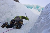 Чоловічий лід альпініст розмахуючи осей в рок обличчя гори привид річки, Альберта, Канада — стокове фото
