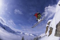 Salto feminino transportado pelo ar esquiador no sertão de Kicking Horse Resort, Golden, British Columbia, Canadá — Fotografia de Stock