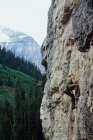 Low angle view of male climber leading climb at Lake Louise, Banff National Park, Alberta, Canada — Stock Photo