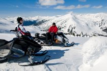 Друзья останавливаются и смотрят на вид во время катания на снегоходах, горы Монаши, Валемунт, Томпсон Оканаган, Британская Колумбия, Канада — стоковое фото
