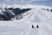 Par de motos de neve explorando picos majestosos de Monashees perto de Valemount, Thompson Okanagan, British Columbia, Canadá — Fotografia de Stock