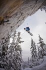 Male skier dropping off cliff at Kicking Horse Resort, Golden, British Columbia, Canada — Stock Photo