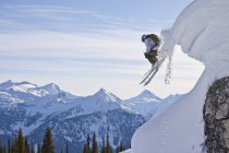 Esquiador masculino arejando fora do travesseiro de neve, Monashee Mountains, Colúmbia Britânica, Canadá — Fotografia de Stock